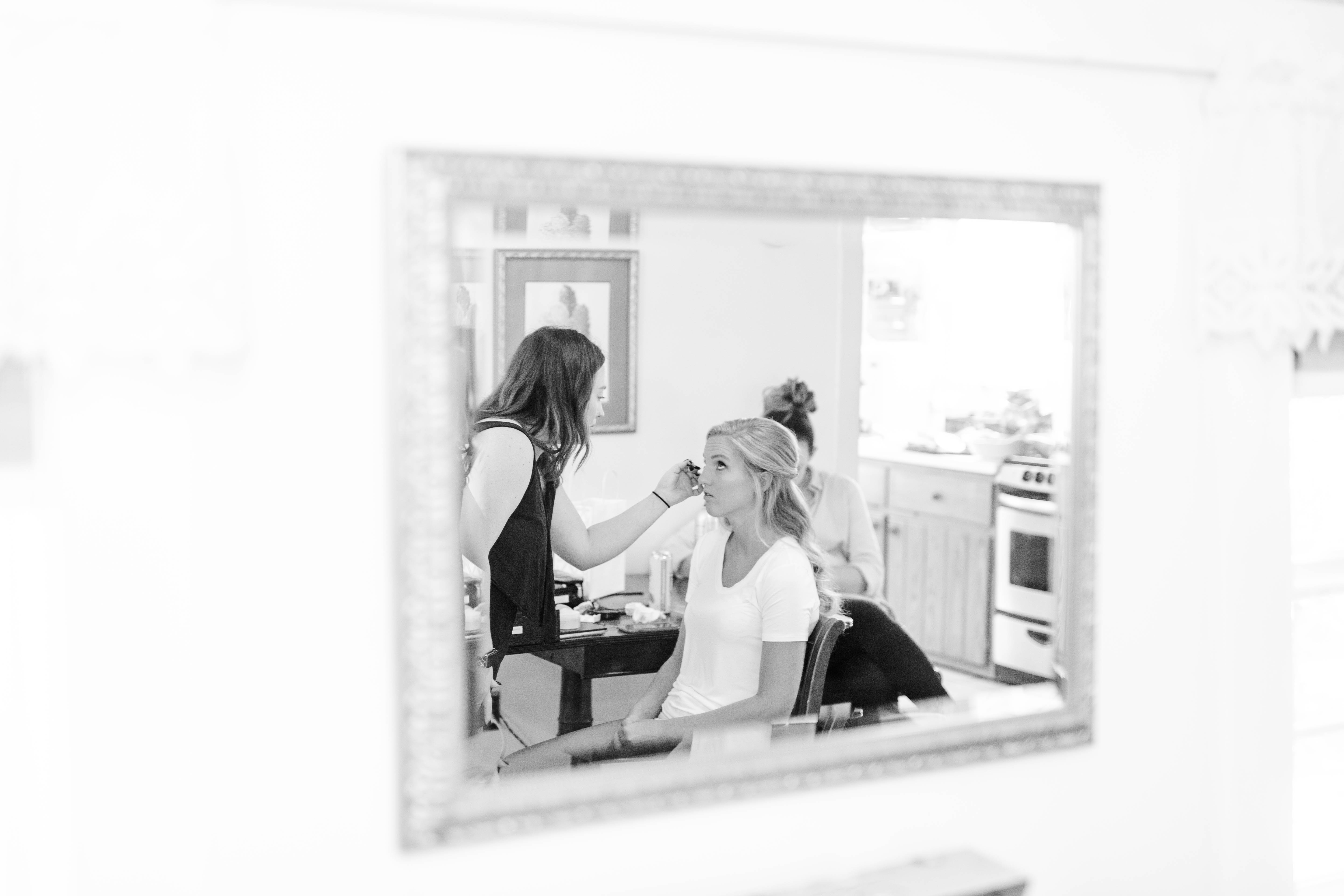 mirror picture of bride getting her make up done