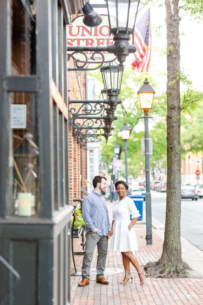 Couple standing in middle of brick paved sidewalk in front of Union Street Pub sign 