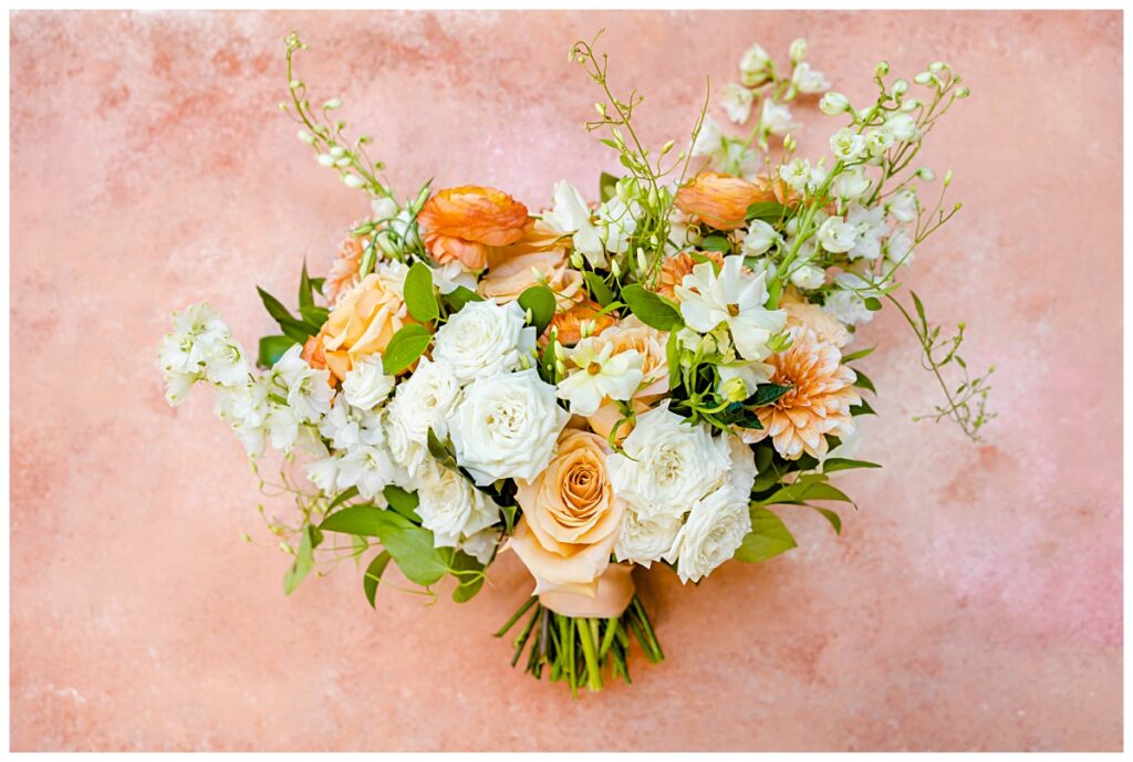 bridal bouquet in a peach, white and green color palette
