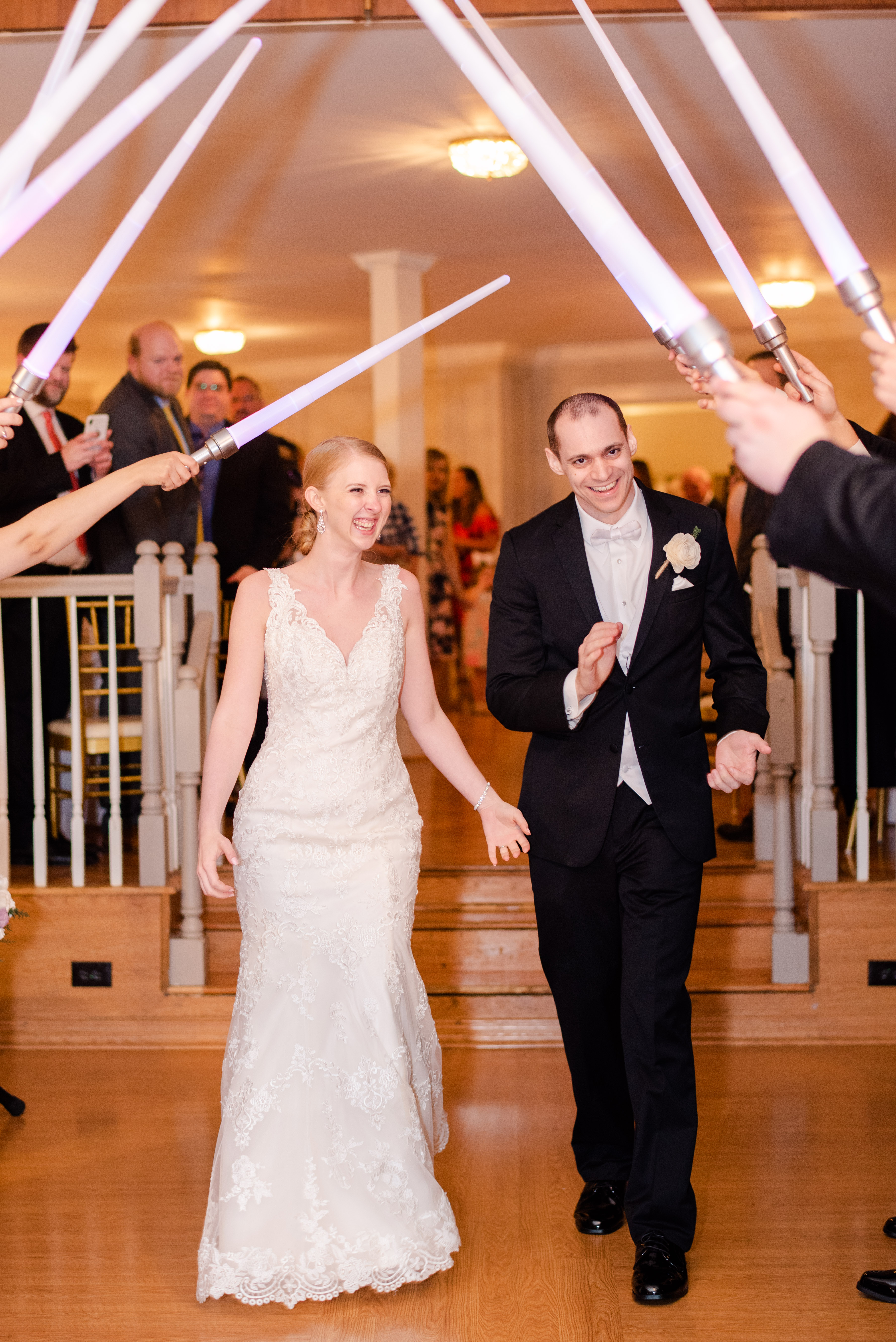 bride and groom walking through a light saber arch