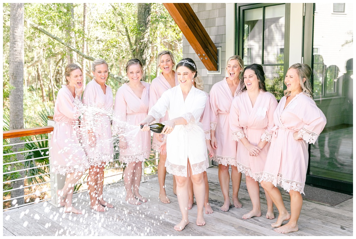 bride spraying champagne with bridesmaids